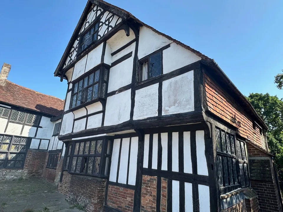 Black-and-white timber-framed building with brickwork at ground level.