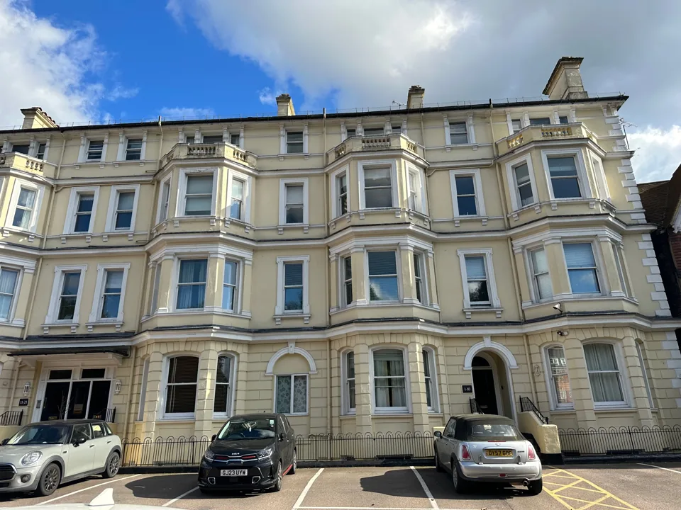 Tall period terrace with decorative bay windows and contrasting facade colours.