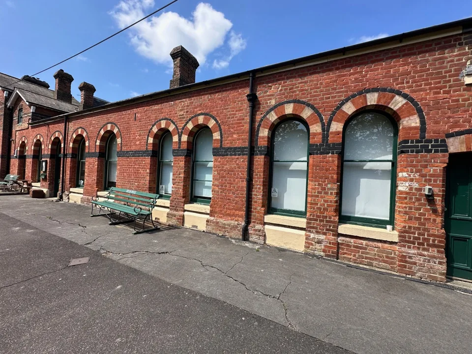 Long single-storey brick frontage with repeated arched windows.