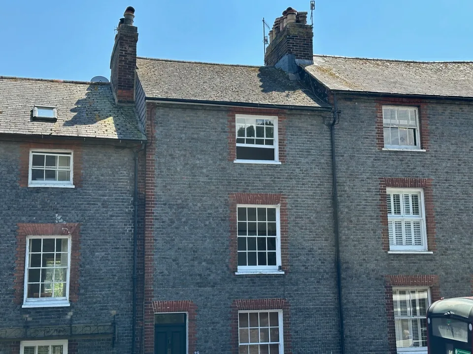 Terraced houses with flint walls, sash windows and tall chimney stacks.